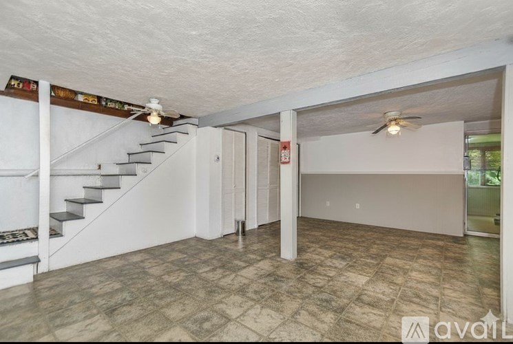 A room with a tiled floor and a staircase.