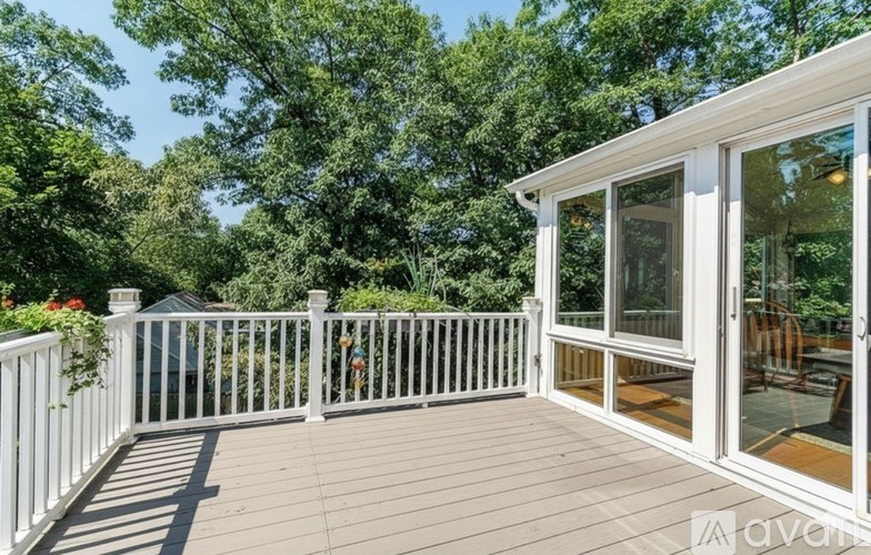 A deck with a white railing and a glass door.