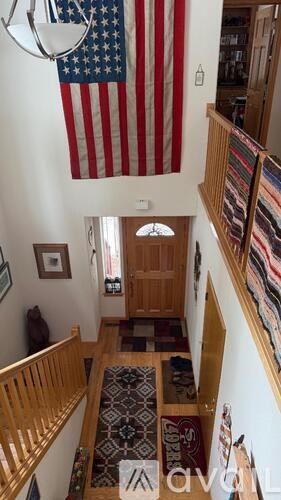 A large American flag hangs from the ceiling in a home.
