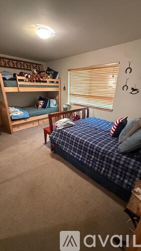 A bedroom with a bed, a bunk bed, and a desk.