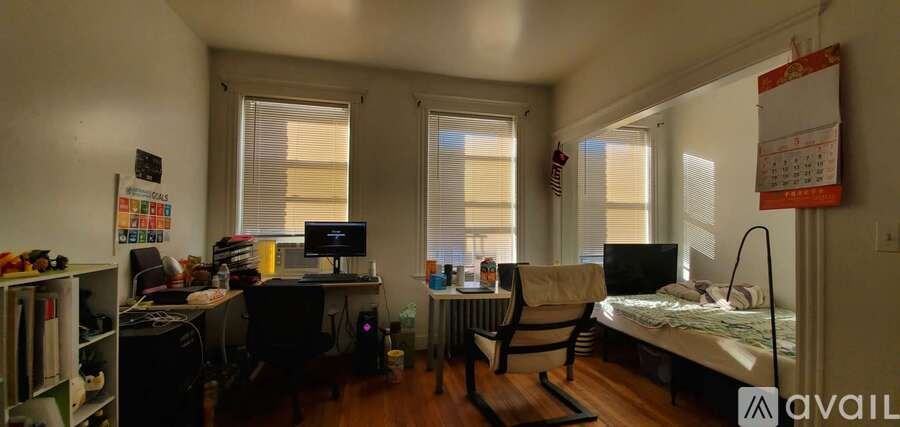 A small room with a bed, desk, and chair.