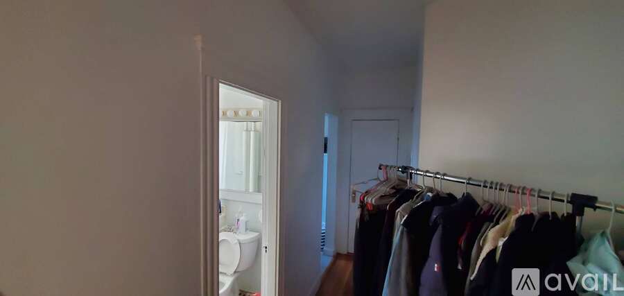 A row of clothes hanging on a rack in a room.