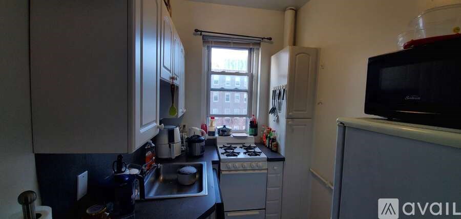 A kitchen with a black counter top and white cabinets.