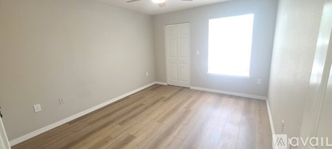 A room with wooden flooring and a white door.
