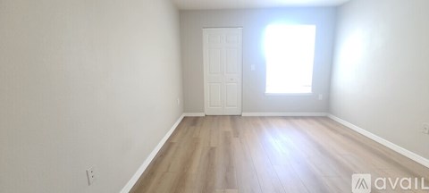 A room with a door and a window with sunlight coming through.