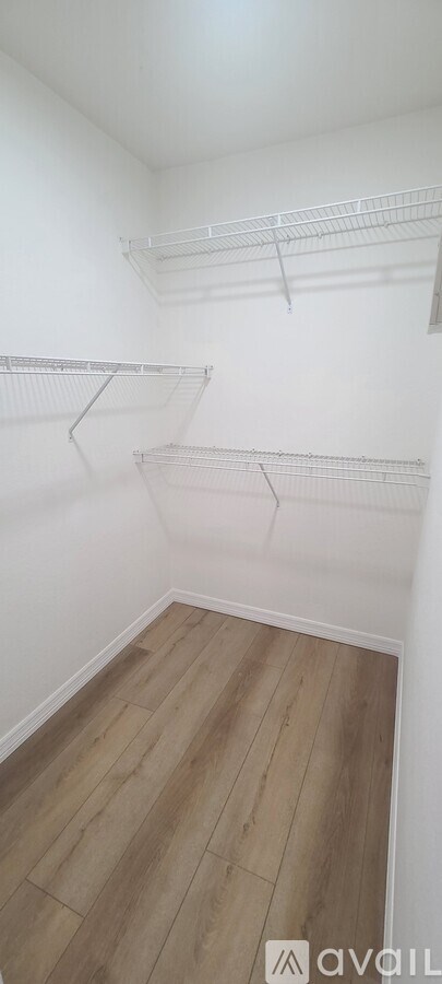 Empty room with white walls and wooden flooring.