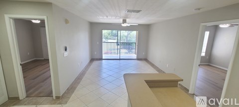 A spacious room with a balcony door and a window.