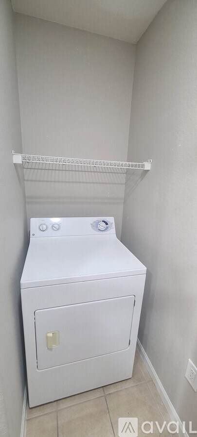 A white washing machine in a small bathroom.