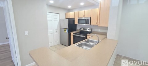A kitchen with a sink, stove, and refrigerator.