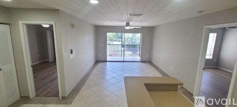 A long, empty hallway with a balcony outside.