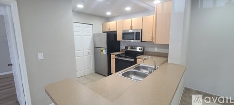 A kitchen with a sink, stove, and refrigerator.
