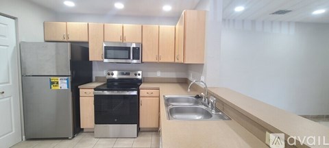 A kitchen with a refrigerator, oven, microwave, and cabinets.