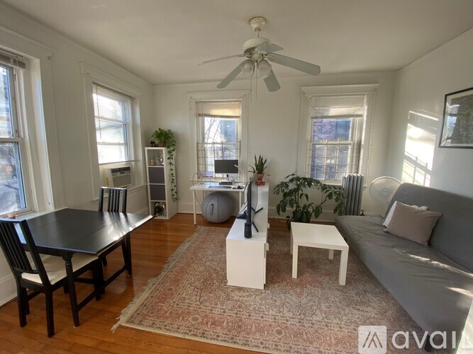 A living room with a black table and a grey couch.