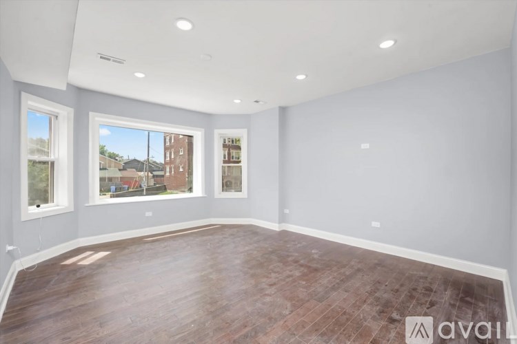 A large empty room with wooden floors and white walls.