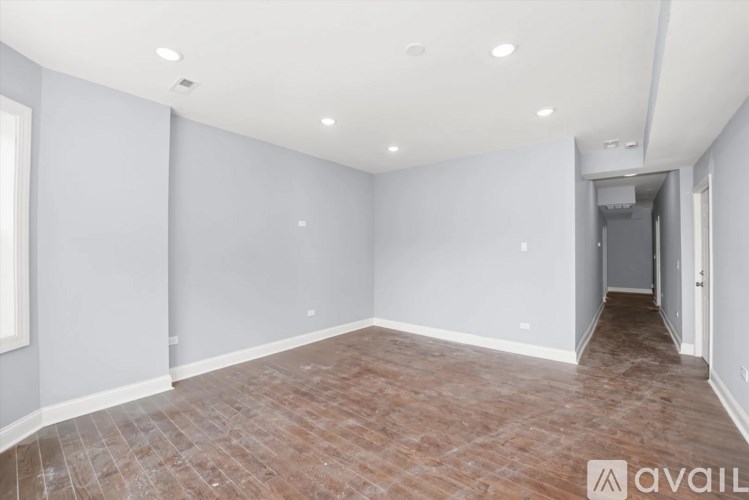 A room with wooden flooring and white walls.