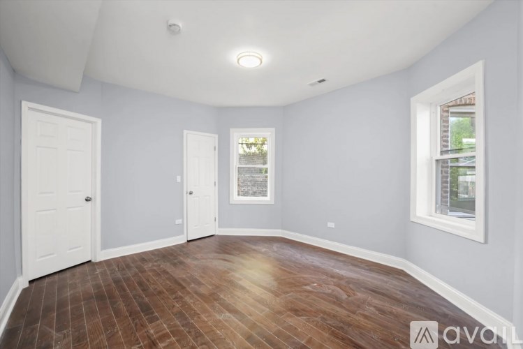 A room with wooden flooring and white walls.