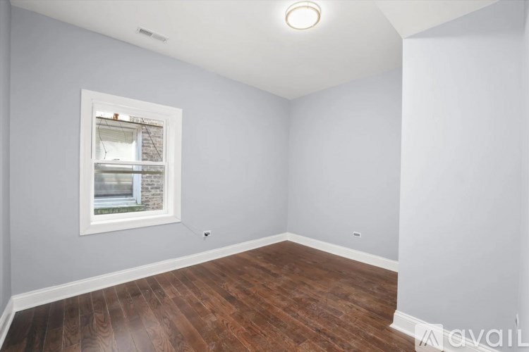 A room with a window and wooden flooring.