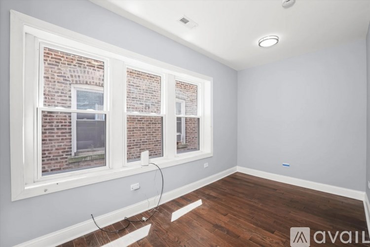 A room with a window overlooking a brick building.