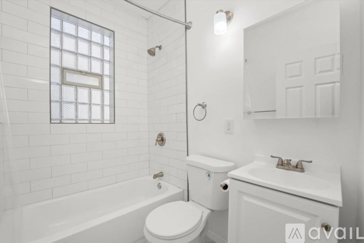 A white bathroom with a toilet, sink, and tub.