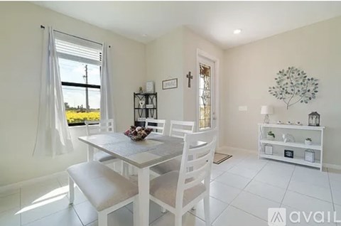 A dining room with a table and chairs.