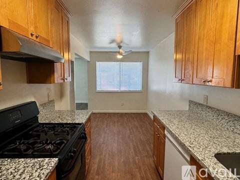 A kitchen with wooden cabinets and a black stove top oven.