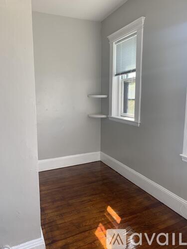 A room with a window and a wooden floor.