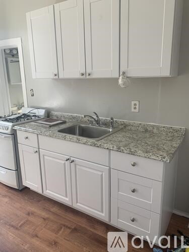 A kitchen with white cabinets and a granite countertop.