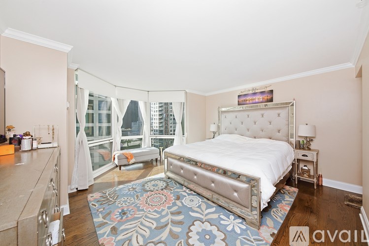 A bedroom with a large bed and a view of the city.