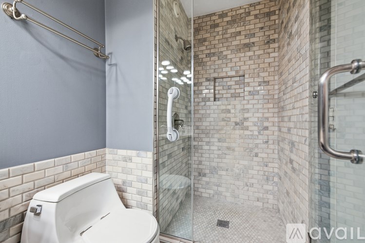 A white toilet is in a bathroom with a glass shower stall.
