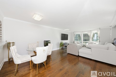 A living room with white furniture and a wooden floor.