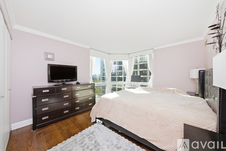 A bedroom with a bed, dresser, and television.