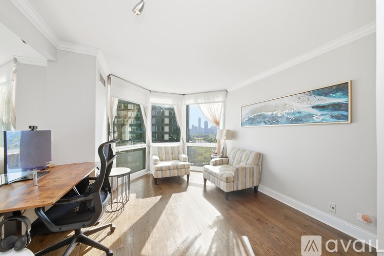 A living room with a couch, chair, and a painting on the wall.