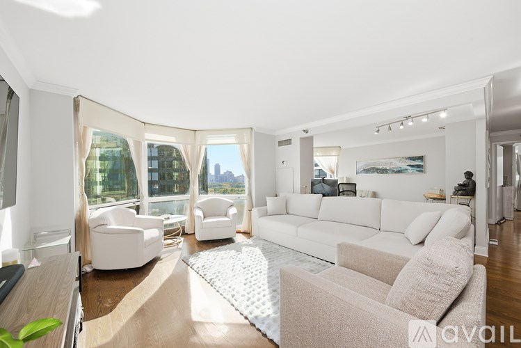 A modern living room with a large window and a view of the city.