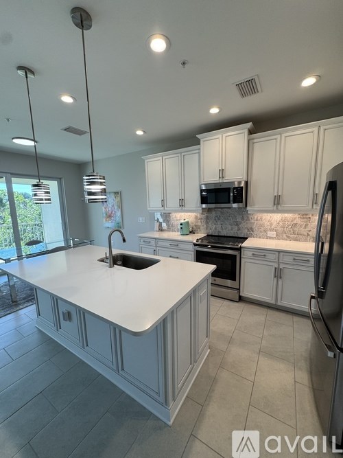 A modern kitchen with white cabinets and a large island.