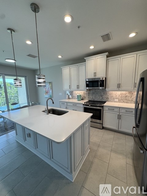 A modern kitchen with white cabinets and a large island.