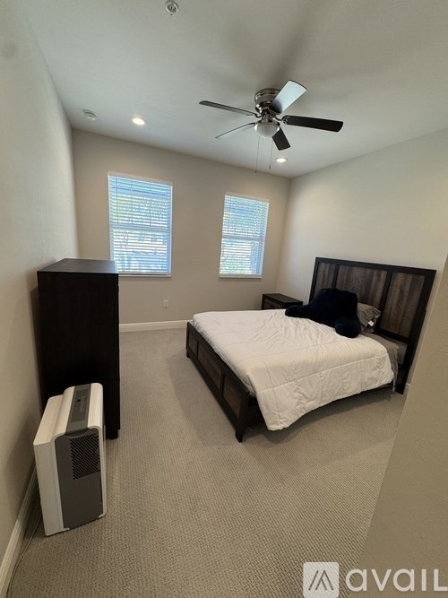 A bedroom with a bed, dresser, and window.