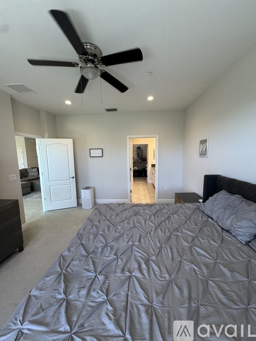 A bedroom with a large bed and a ceiling fan.