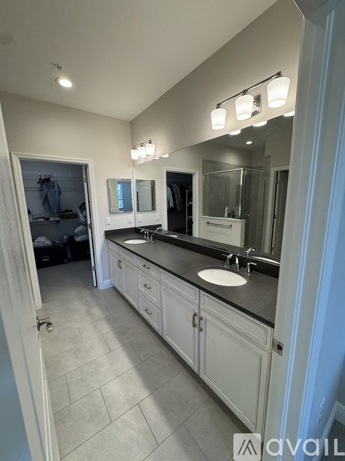 A bathroom with a sink, mirror, and lighting fixtures.