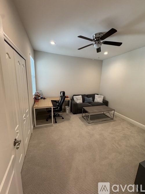 A room with a ceiling fan and a couch.
