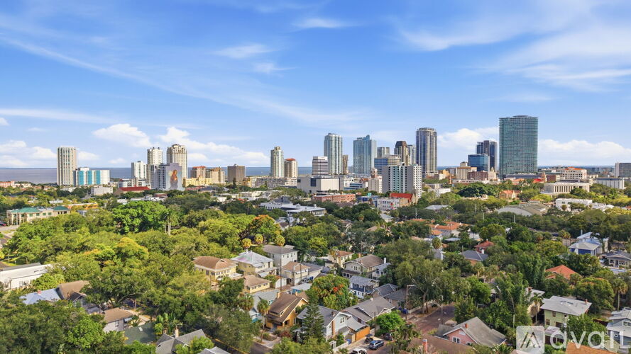 A cityscape with a mix of residential and commercial buildings under a clear sky.