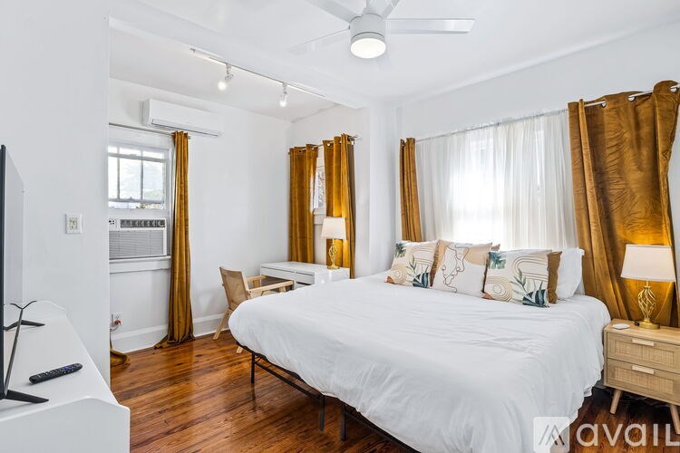 A bedroom with a large bed, a desk, and a chair.