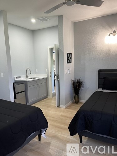 A bedroom with a bed, a sink, and a mirror.