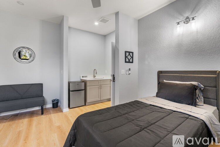 A bedroom with a large bed and a grey sofa.