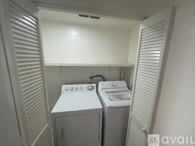 A small laundry room with a washer and dryer.