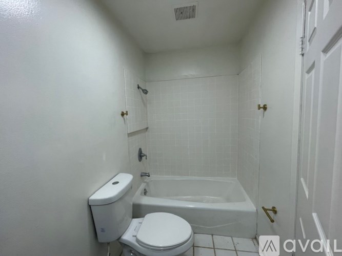 A white bathroom with a toilet, sink, and bathtub.