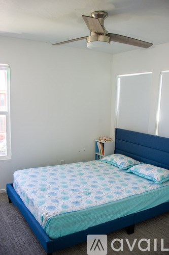 A bedroom with a bed and a ceiling fan.