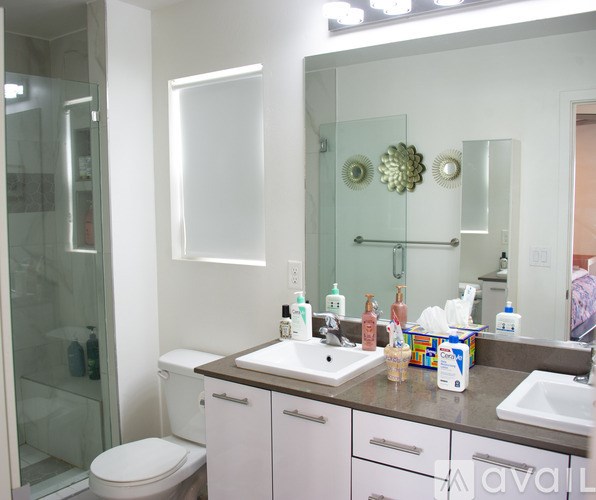 A bathroom with a white toilet, sink, and mirror.
