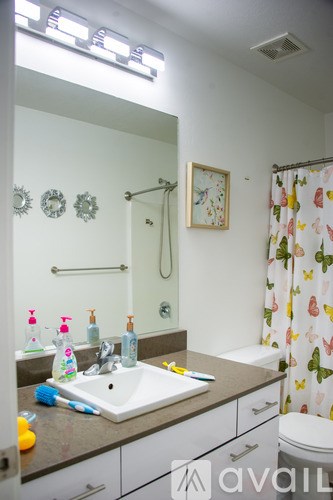 A bathroom with a sink, mirror, and shower.