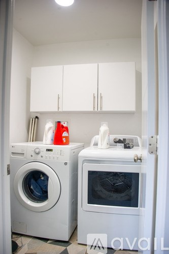 A white washing machine and dryer in a laundry room.