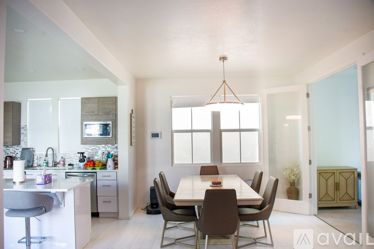 A modern kitchen with a dining table and chairs.